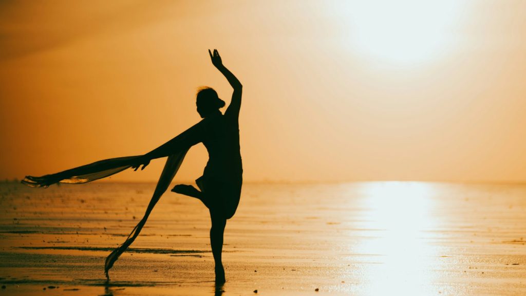 Donna che danza sul mare all'alba